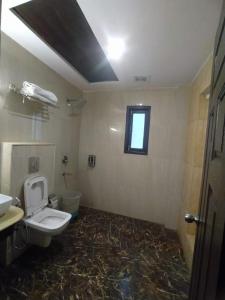 a bathroom with a toilet and a window at Tara valley view in Gangtok