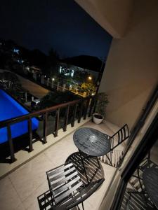 Bukit Jaya Residence & Apartment Semarang في سيمارانغ: طاولة وكرسي على شرفة في الليل