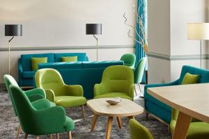 a waiting room with blue and green chairs and a table at Leonardo Hotel Newcastle in Newcastle upon Tyne