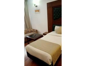 a hotel room with a bed and a chair at Hotel Solitaire, Chandigarh in Chandīgarh