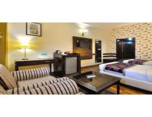 a hotel room with a bed couch and a tv at Hotel Solitaire, Chandigarh in Chandīgarh