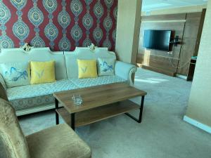 a living room with a couch and a coffee table at Jasper Hotel in Darhan