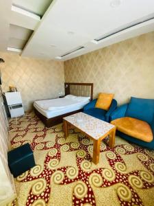 een kamer met een bed, een bank en een tafel bij Jasper Hotel in Darhan