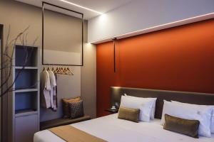 una camera con un letto con una parete arancione di Albergo La Pace a Segni