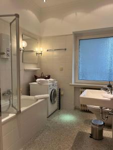 a bathroom with a washing machine and a sink at Suite Appartement Friesenhof in Hannover