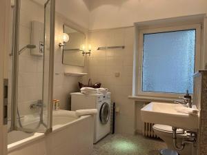 a bathroom with a sink and a washing machine at Suite Appartement Friesenhof in Hannover