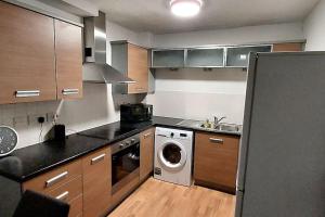 eine Küche mit einer Waschmaschine und einem Geschirrspüler in der Unterkunft Large 2 bed flat in Bolton in Farnworth