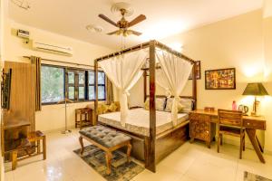 a bedroom with a canopy bed and a desk at House Of Comfort Greater Noida Luxury in Greater Noida