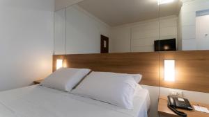 Postel nebo postele na pokoji v ubytování Hotel Glória Blumenau