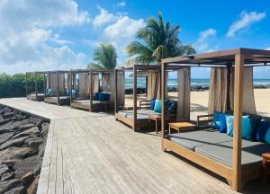 a row of beds on a boardwalk on the beach at InterContinental Mauritius Resort Balaclava Fort, an IHG Hotel in Balaclava