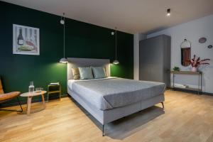 1 dormitorio con cama y pared verde en ipartment Berlin Mitte, en Berlín