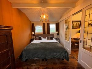 a bedroom with a bed and a chandelier at Hoeve de Knol in Holthees