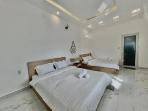 Dos camas en una habitación con paredes blancas. en CT Villa, en Xuan An 10 fotos más
