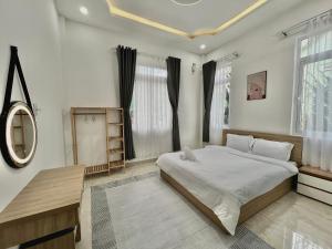 a bedroom with a large bed and a mirror at CT Villa in Xuan An