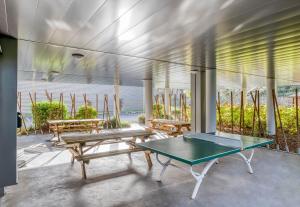 un patio avec deux bancs et une table dans l'établissement B&B HOTEL Bordeaux Langon, à Langon