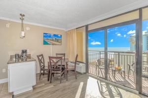 默特尔比奇Immaculate Ocean View Suite!-Caravelle Resort 1004-Sleeps 6 Guests!的一间带桌子的用餐室和一个阳台