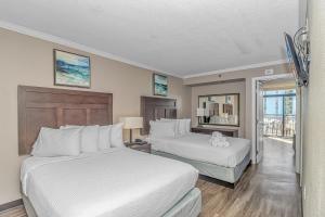 默特尔比奇Immaculate Ocean View Suite!-Caravelle Resort 1004-Sleeps 6 Guests!的有两张床和一个阳台的酒店房间