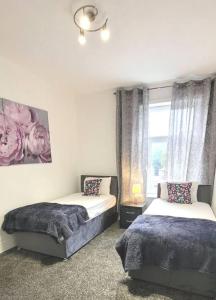 een slaapkamer met 2 bedden en een raam bij 4-Bed House in Accrington in Accrington