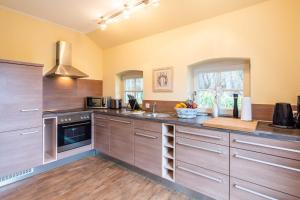 a kitchen with stainless steel appliances and wooden cabinets at Ferienhaus Silbermöwe in Stubbenfelde