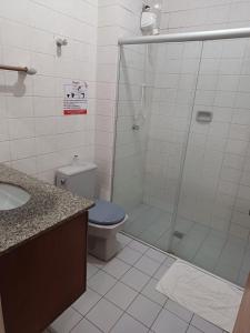 a bathroom with a shower with a toilet and a sink at Hotel Chantilly in Presidente Prudente