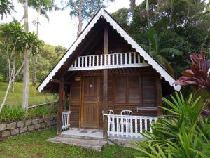 Cabaña de madera pequeña con porche en un jardín en Recanto Floripa, en Florianópolis