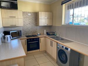a kitchen with a sink and a dishwasher at Unit 11 - Damara Gardens in Windhoek