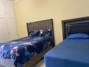 a bedroom with two twin beds with blue sheets at Unit 11 - Damara Gardens in Windhoek