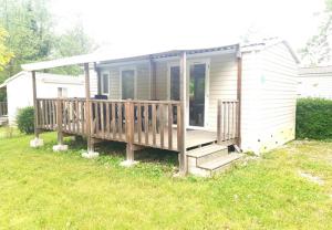 a small house with a porch and a deck at Camping Onlycamp Les Peupliers du Lac in Chindrieux