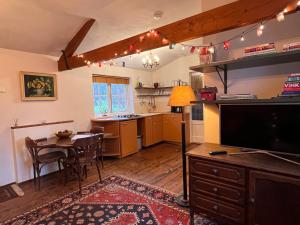a kitchen with a table and a tv in a room at Hoeve de Knol in Holthees