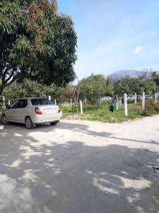 um carro branco estacionado na berma de uma estrada em Nature stay-the Himalayan foot hills -JANAKI SADAN em Jhājra