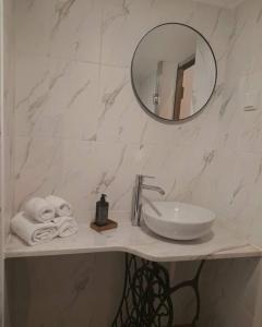 een badkamer met een wastafel, een spiegel en handdoeken bij Porta 28 in Penacova