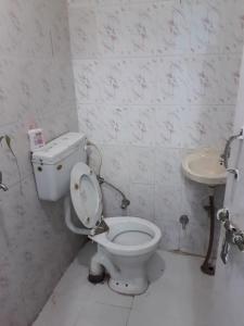 a bathroom with a toilet and a sink at Nature Stay-The Himalayan Foot Hills-JANAKI SADAN Two Bed Room Garden Home with attached bath room in each room and Kitchen with garden facing dinning space with Badminton Court in Mango Orchard in Jhājra +51 photos