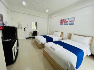 ein Hotelzimmer mit 2 Betten und einem Flachbild-TV in der Unterkunft The Sceneสุพรรณบุรี in Suphan Buri