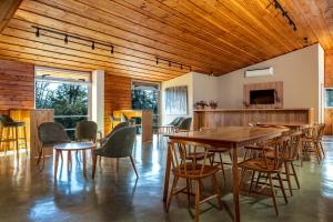 a dining room with wooden ceilings and tables and chairs at Montaña Resort in Villa La Angostura