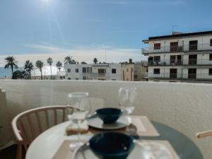 einen Tisch mit zwei Gläsern auf dem Balkon in der Unterkunft Femina Blue in Cambrils