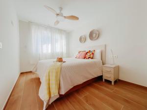 ein weißes Schlafzimmer mit einem Bett und einem Deckenventilator in der Unterkunft Femina Blue in Cambrils + 26 Fotos