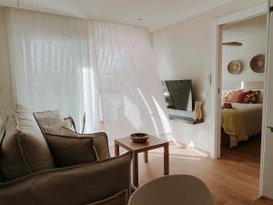 ein Wohnzimmer mit einer Couch, einem Tisch und einem Bett in der Unterkunft Femina Blue in Cambrils