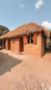 een klein gebouw met een rieten dak bij Muke Village Guest House in Livingstone