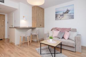 salon z kanapą i stołem w obiekcie Apartamenty Jantaris II by Renters w mieście Mielno