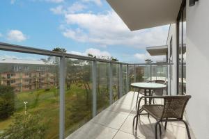 a balcony with a table and chairs and a view at Apartamenty Jantaris II by Renters in Mielno