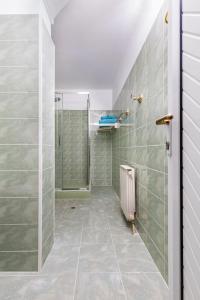 a bathroom with a shower and a tiled floor at A Nostalgic Getaway in Plovdiv's Historic Quarter in Plovdiv