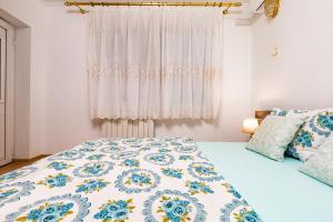 a bedroom with a bed with a blue and white comforter at A Nostalgic Getaway in Plovdiv's Historic Quarter in Plovdiv