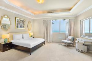 a bedroom with a bed and a desk and a piano at Al Hamra Residence in Ras al Khaimah