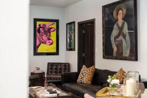 a living room with a couch and paintings on the wall at LIFT LODGE 102 condo in Park City