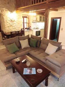 a living room with a brown couch and a coffee table at Παραδοσιακός Ξενώνας Λυμπέρη in Koíta