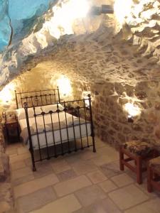 a bedroom in a cave with two beds in it at Παραδοσιακός Ξενώνας Λυμπέρη in Koíta