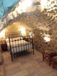 1 dormitorio en una cueva con 2 camas en Παραδοσιακός Ξενώνας Λυμπέρη, en Koíta