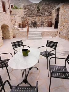 uma mesa e cadeiras com uma chávena de café no pátio em Παραδοσιακός Ξενώνας Λυμπέρη em Koíta