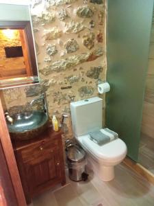a bathroom with a white toilet and a sink at Παραδοσιακός Ξενώνας Λυμπέρη in Koíta