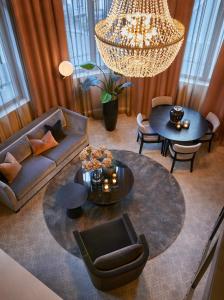 a living room with a couch and tables and a chandelier at Opus 16 in Bergen